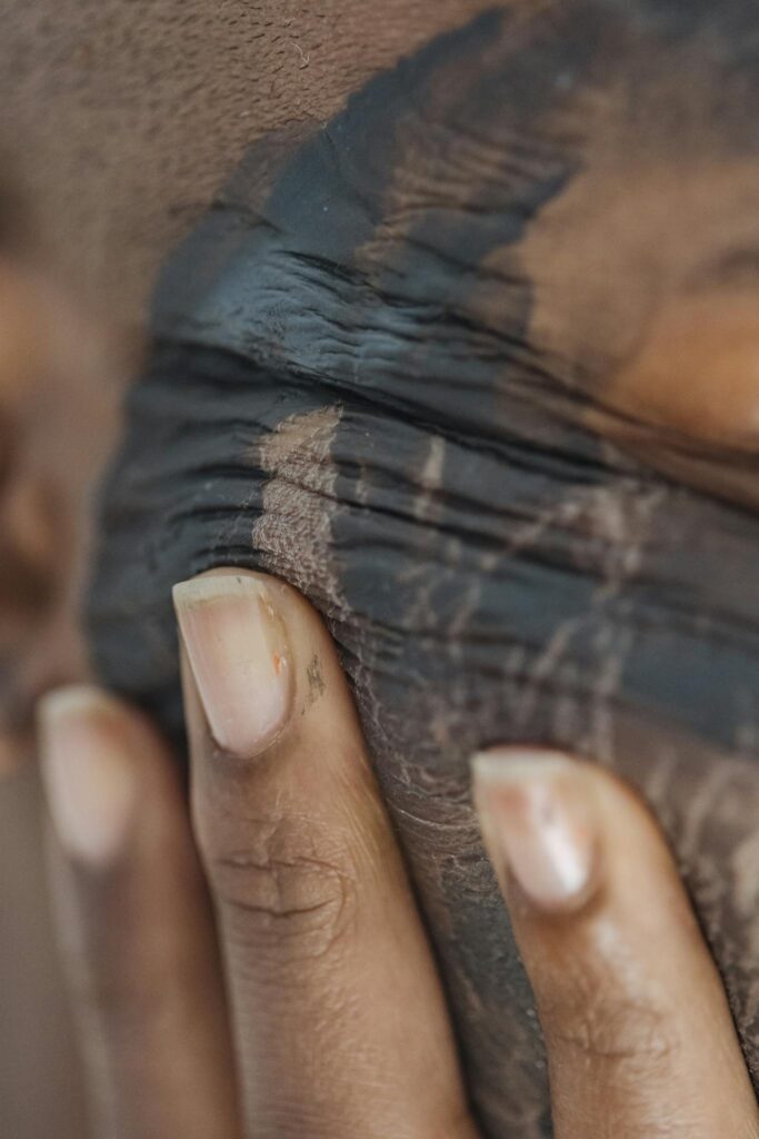 Crop black woman with clay mask on face